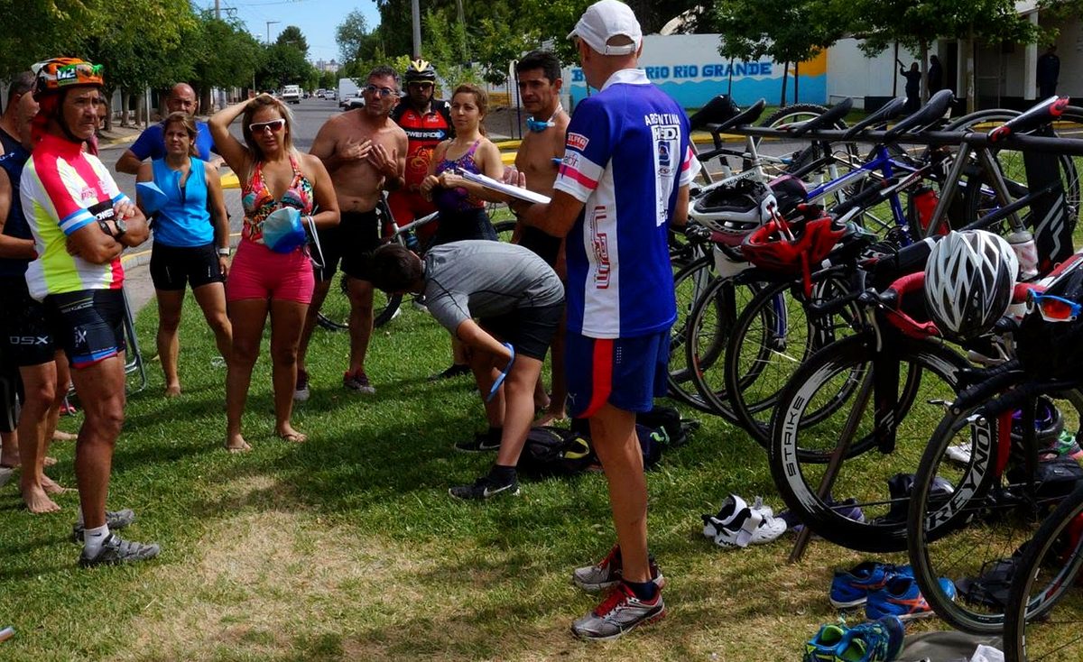 Marcelo Noguera dando una charla técnica a un grupo de triatletas junto a las bicicletas
